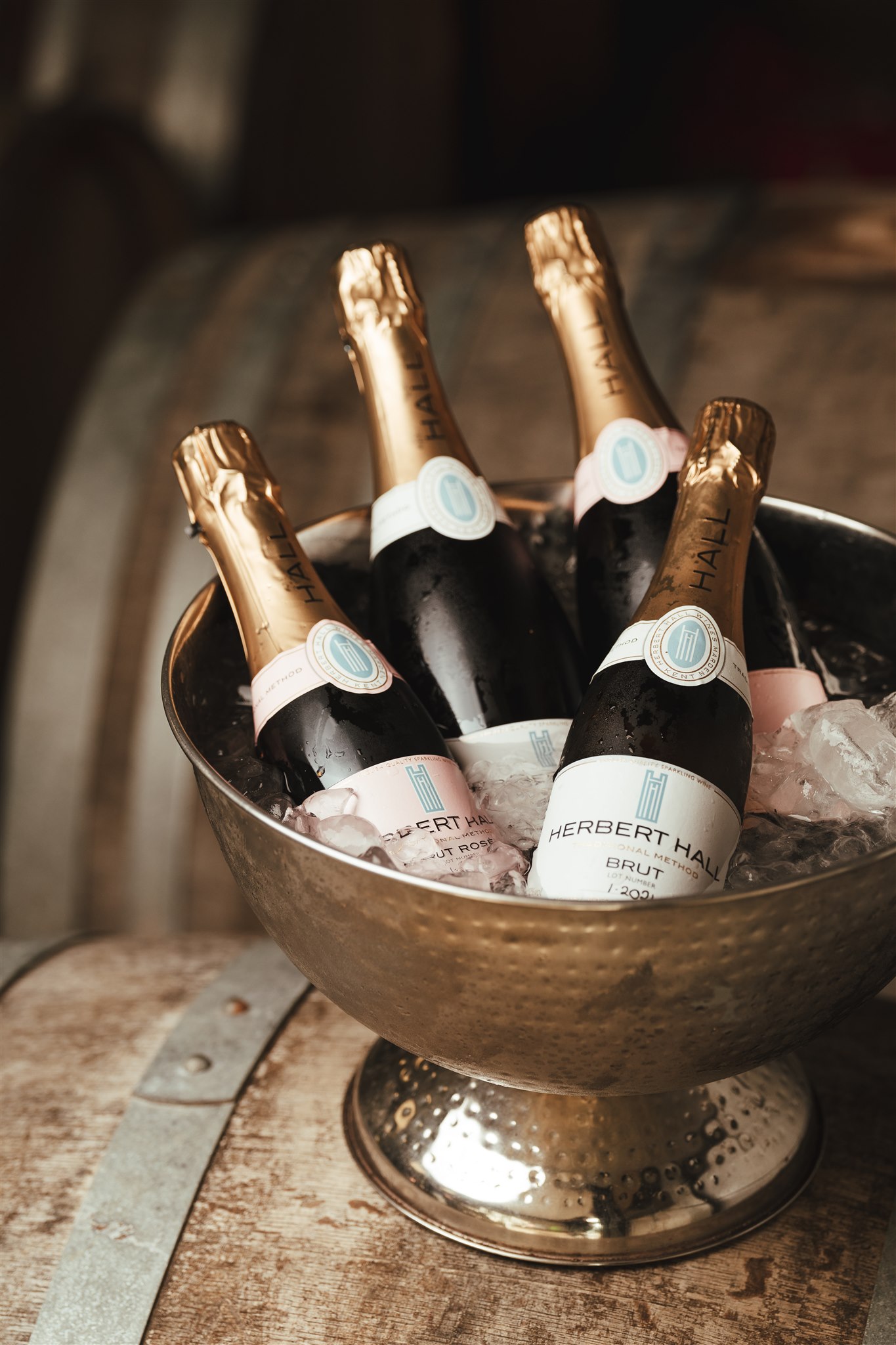 Herbert Hall wines in an ice bucket on a wooden barrel