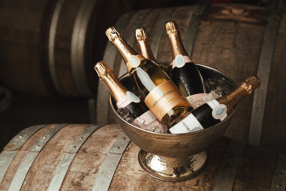 Herbert Hall Winery Wines Herbert Hall wines in an ice bucket on top of a wine barrel.